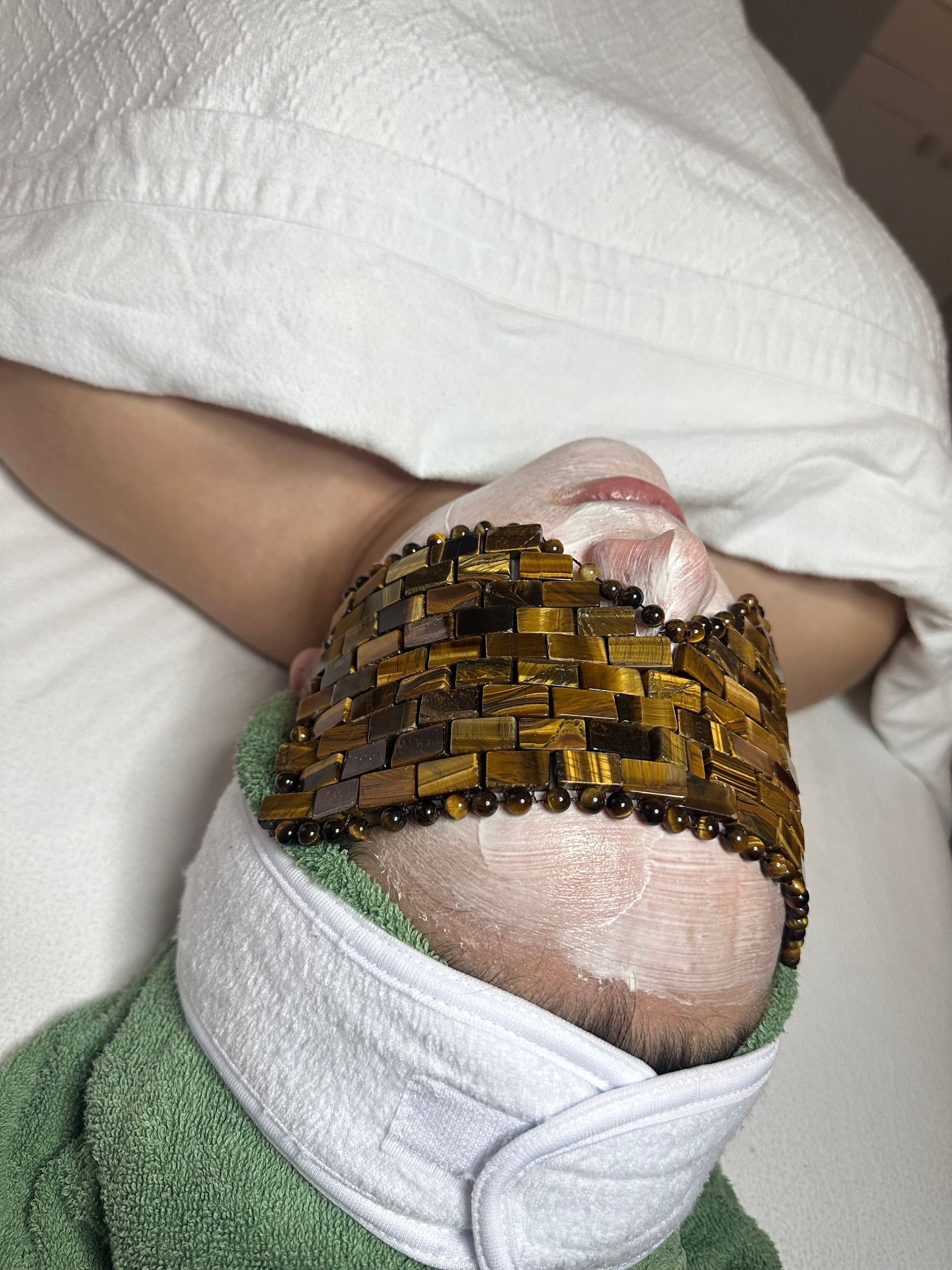 A woman is laying on a bed with a mask on her face.