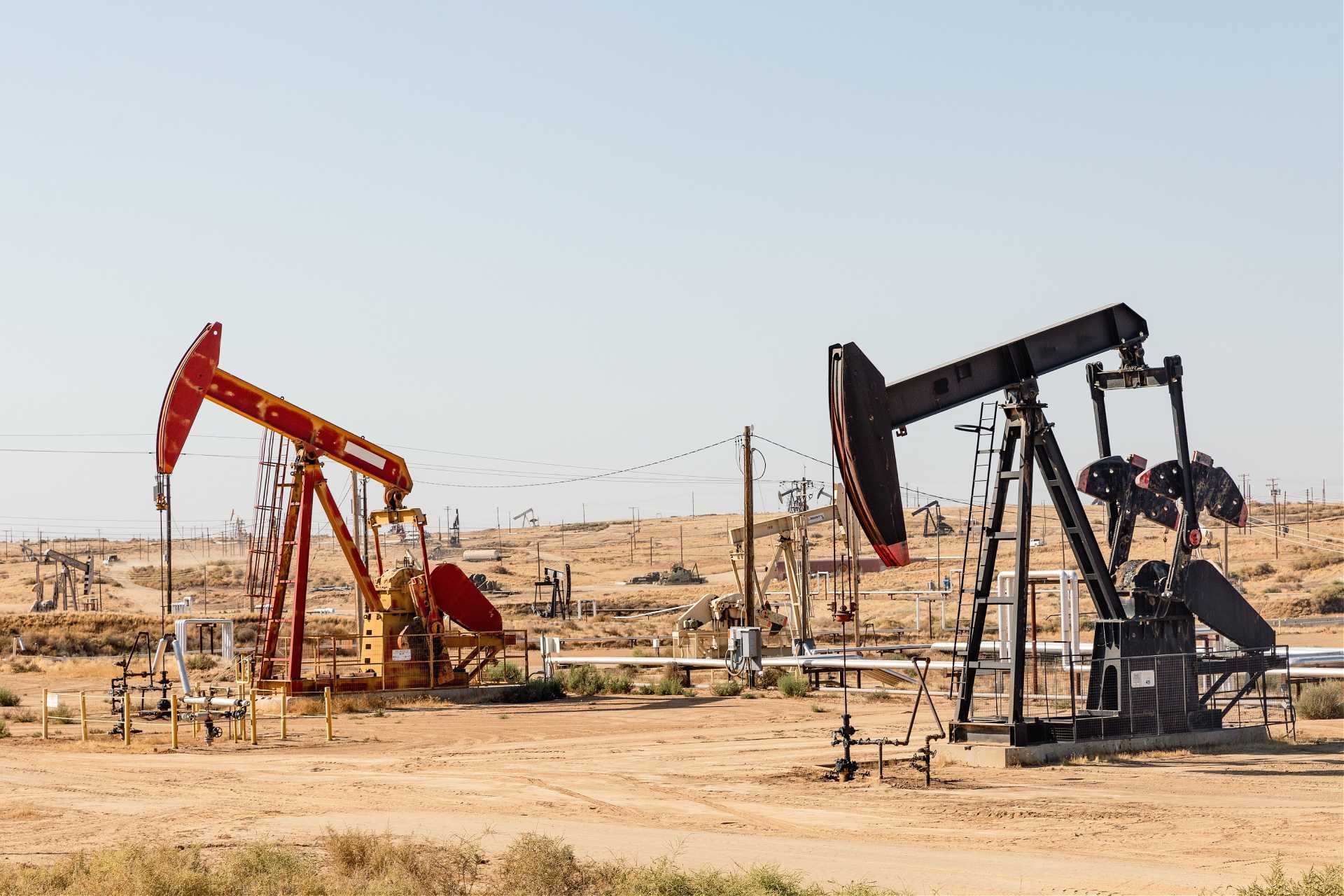 Two oil pump jacks in a desert landscape