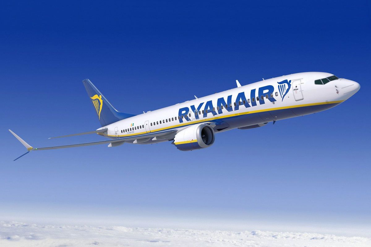 a ryanair plane is flying through a blue sky .