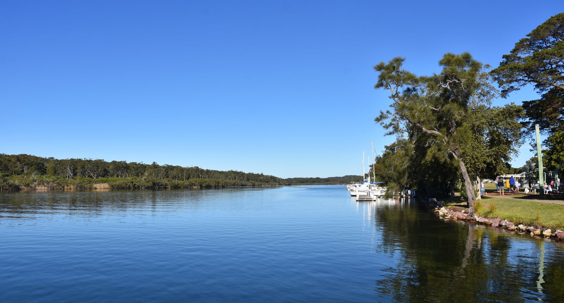 Calm Water of a River or Inlet Under a Blue Sky, Bordered by Trees — FAW Electrical in Sussex Inlet, NSW