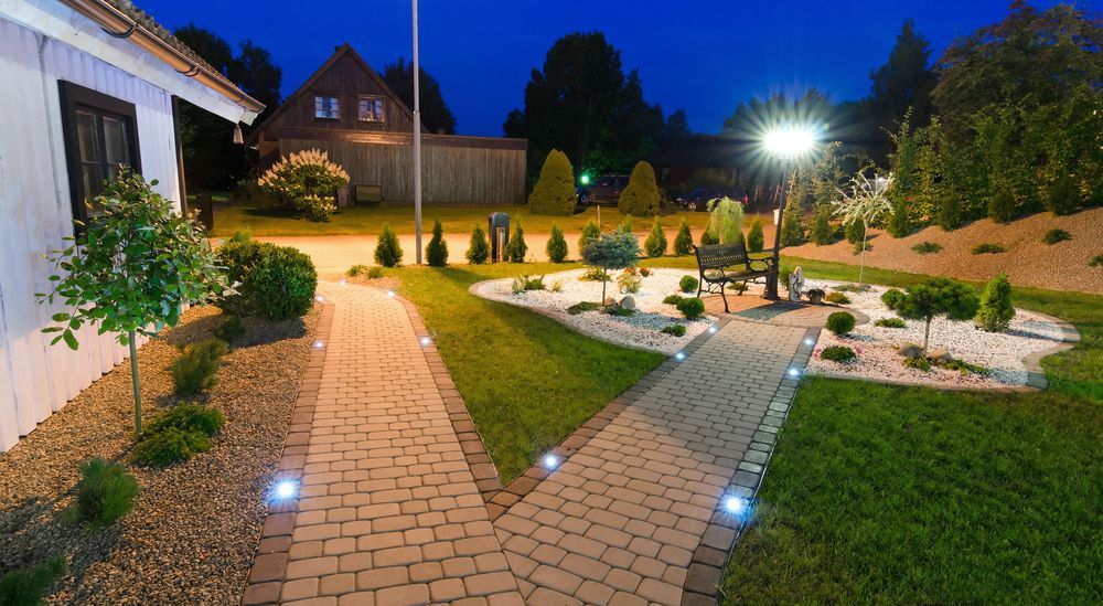 Brick Pathways Lead Through a Well-lit Garden at Dusk — FAW Electrical in Nowra Hill, NSW