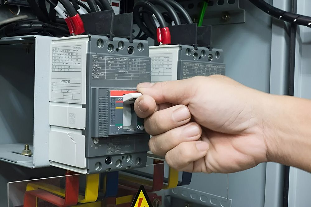 Hand Flipping A Circuit Breaker Switch In An Electrical Panel — FAW Electrical in Nowra Hill, NSW