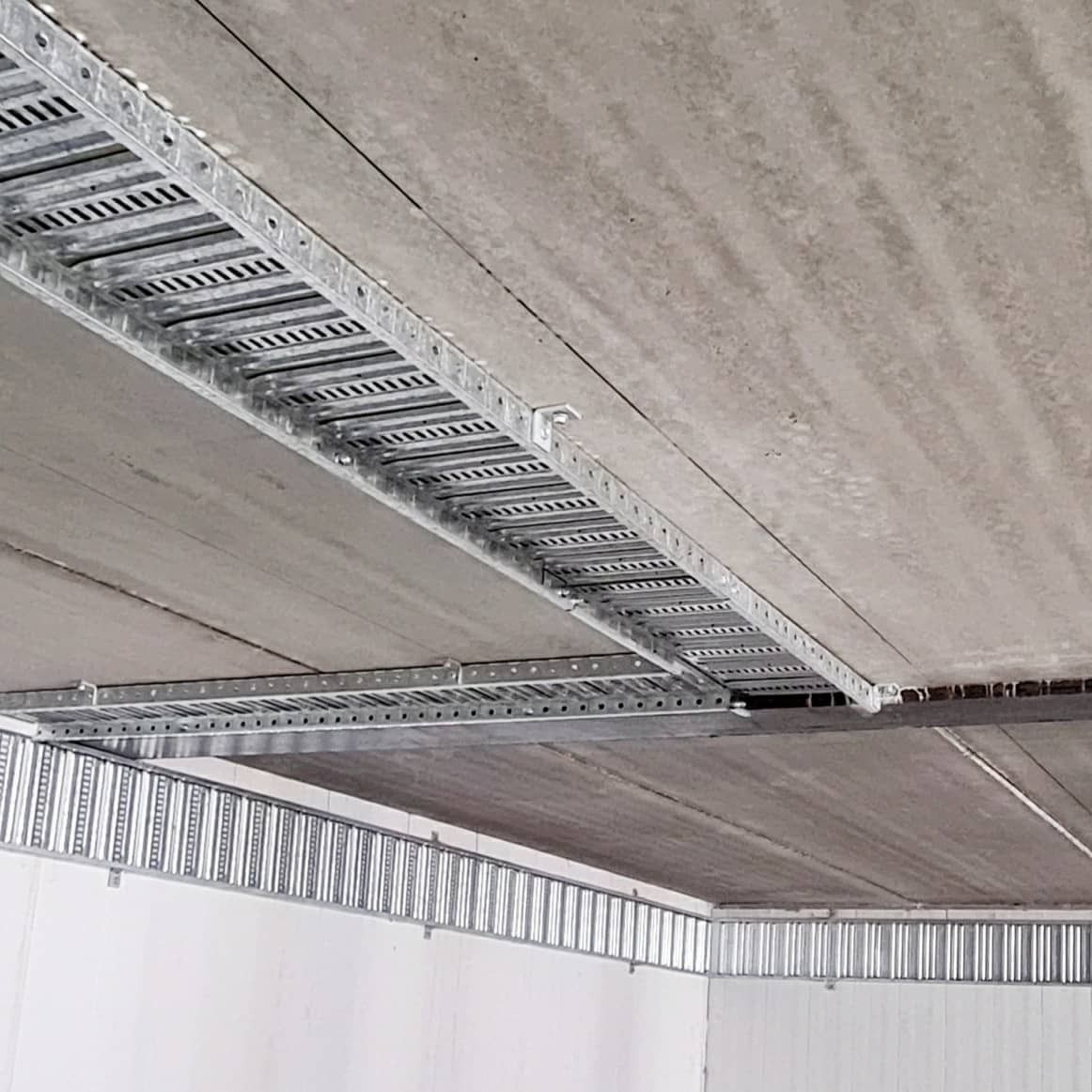 Metal Cable Trays Run Along a Concrete Ceiling — FAW Electrical in Berry, NSW