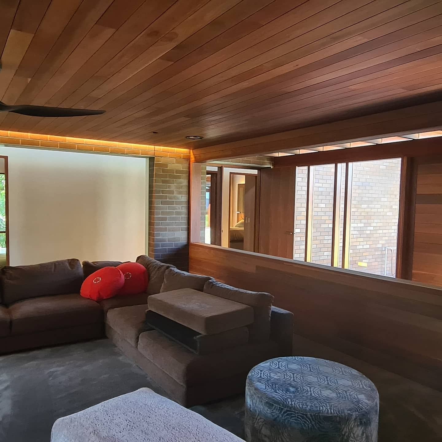 Cozy Living Room With Brown Sectional Sofa — FAW Electrical in Berry, NSW