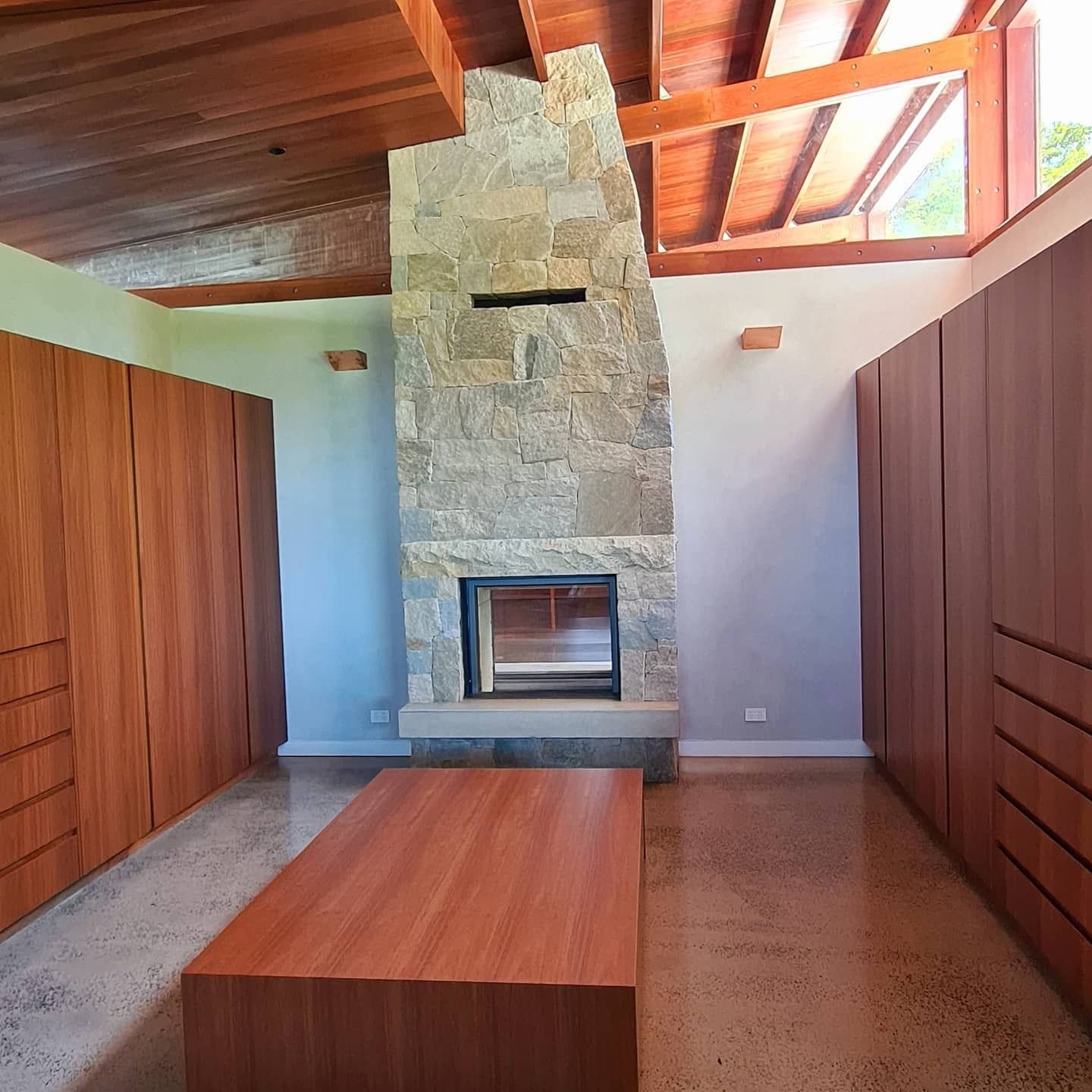 A Modern Bedroom With a Stone Fireplace — FAW Electrical in Nowra Hill, NSW