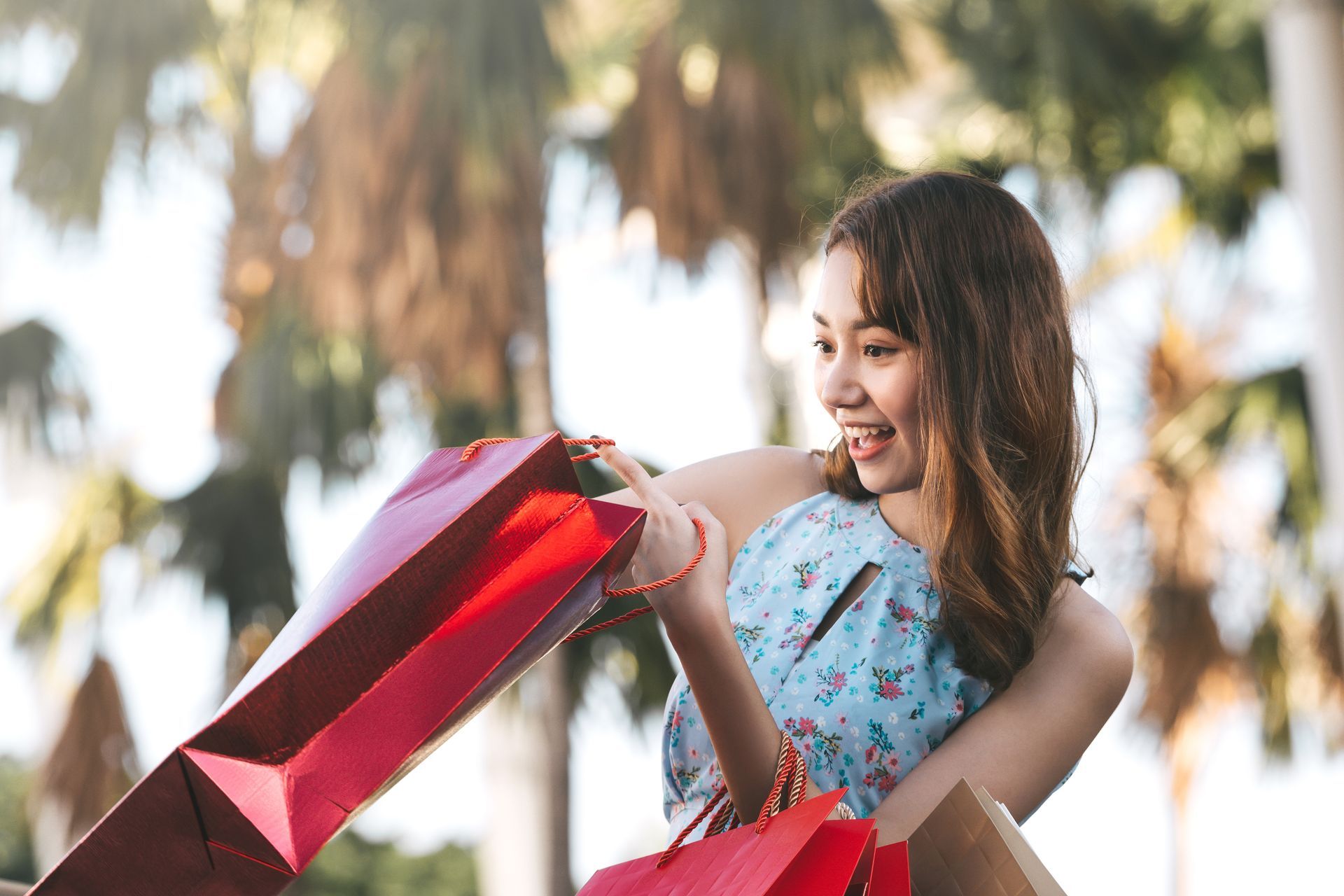 Happy young adult asian woman with shopping bags. 