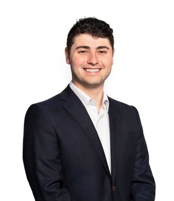 A man in a suit and white shirt is smiling for the camera