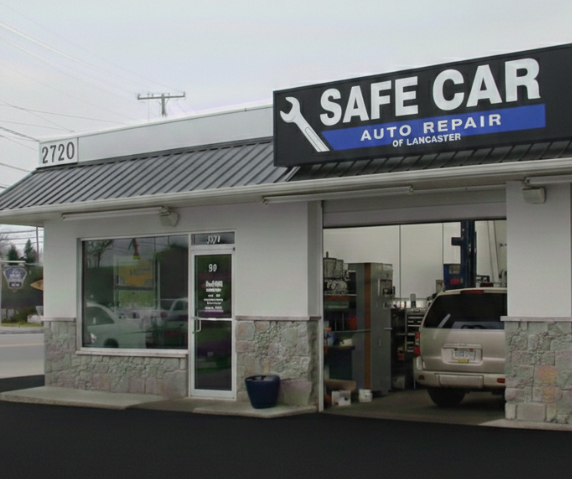 Safe Car Auto Repair shop exterior with a car in the bay, light blue and black sign. | SafeCar Auto Repair of Lancaster