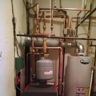 Copper pipes and water heater in a utility room.