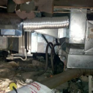 Metal HVAC system in a crawl space with flexible ductwork and wiring.