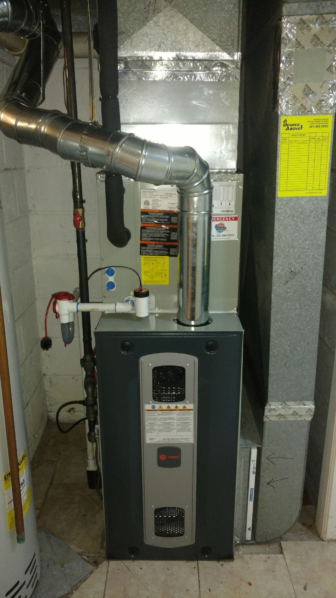 A gas furnace with ductwork and a chimney vent in a basement setting.
