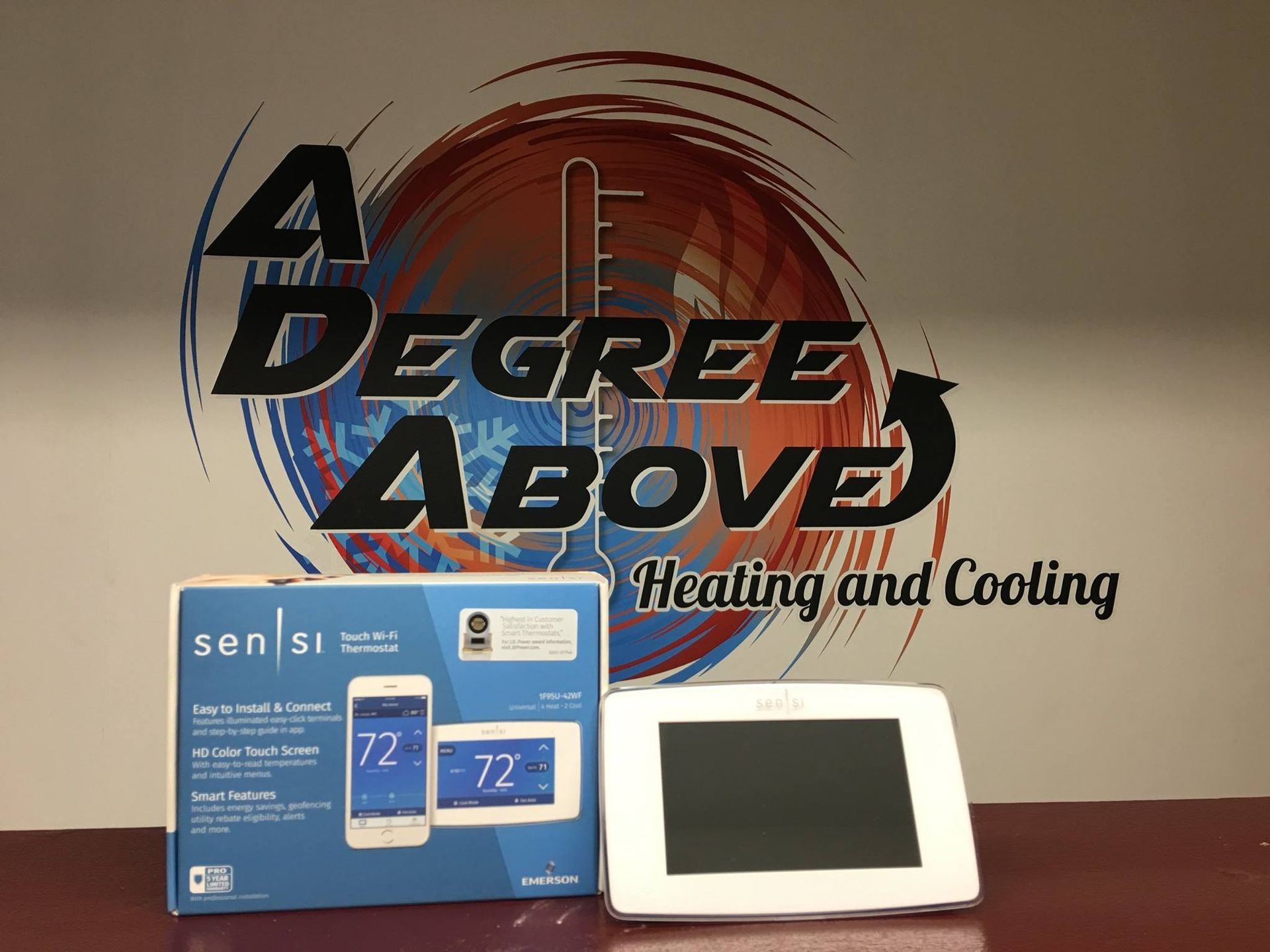 Boxed and installed Sensi thermostat next to a logo for 