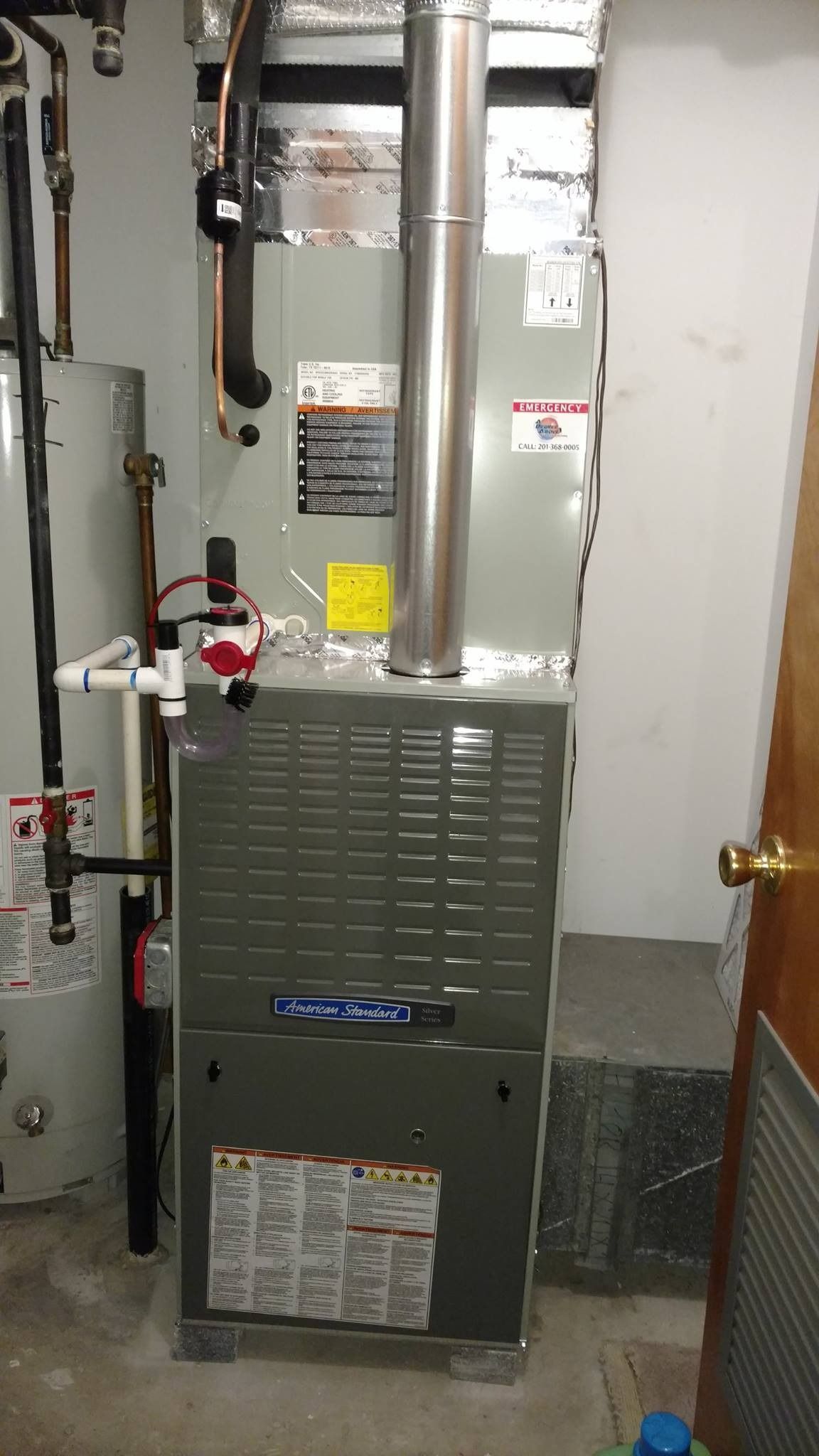 Furnace and water heater in a utility room. Gray metal appliances. Plumbing and vents visible.