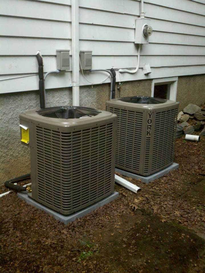 Two York air conditioning units outside a building. Brown, rectangular, with gray metal grills.