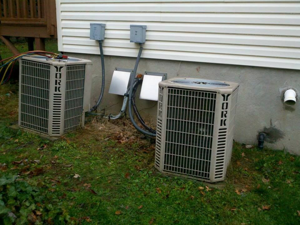 Two York air conditioning units outside a building with electrical boxes.