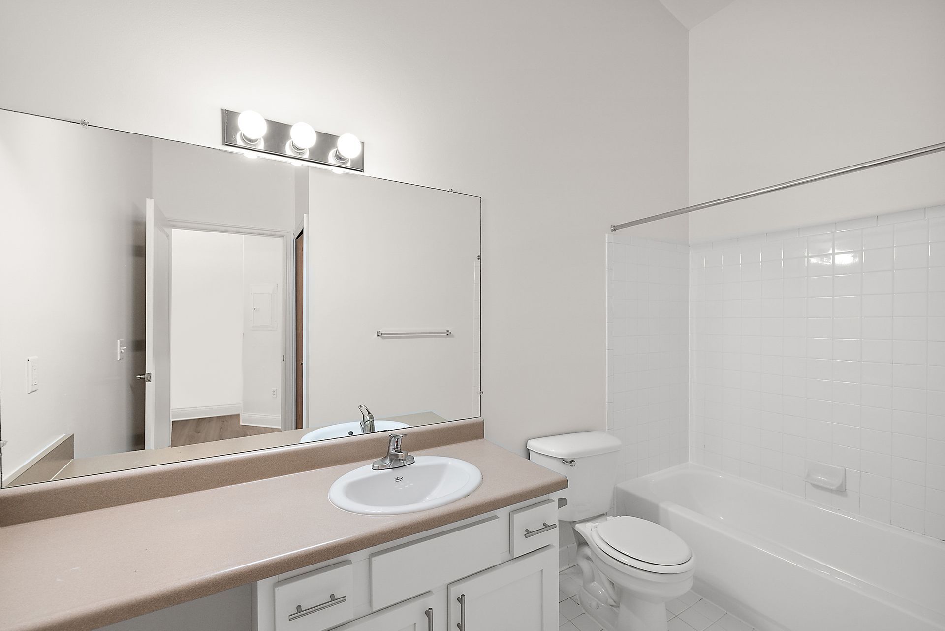 A bathroom with a sink , toilet , tub and mirror.