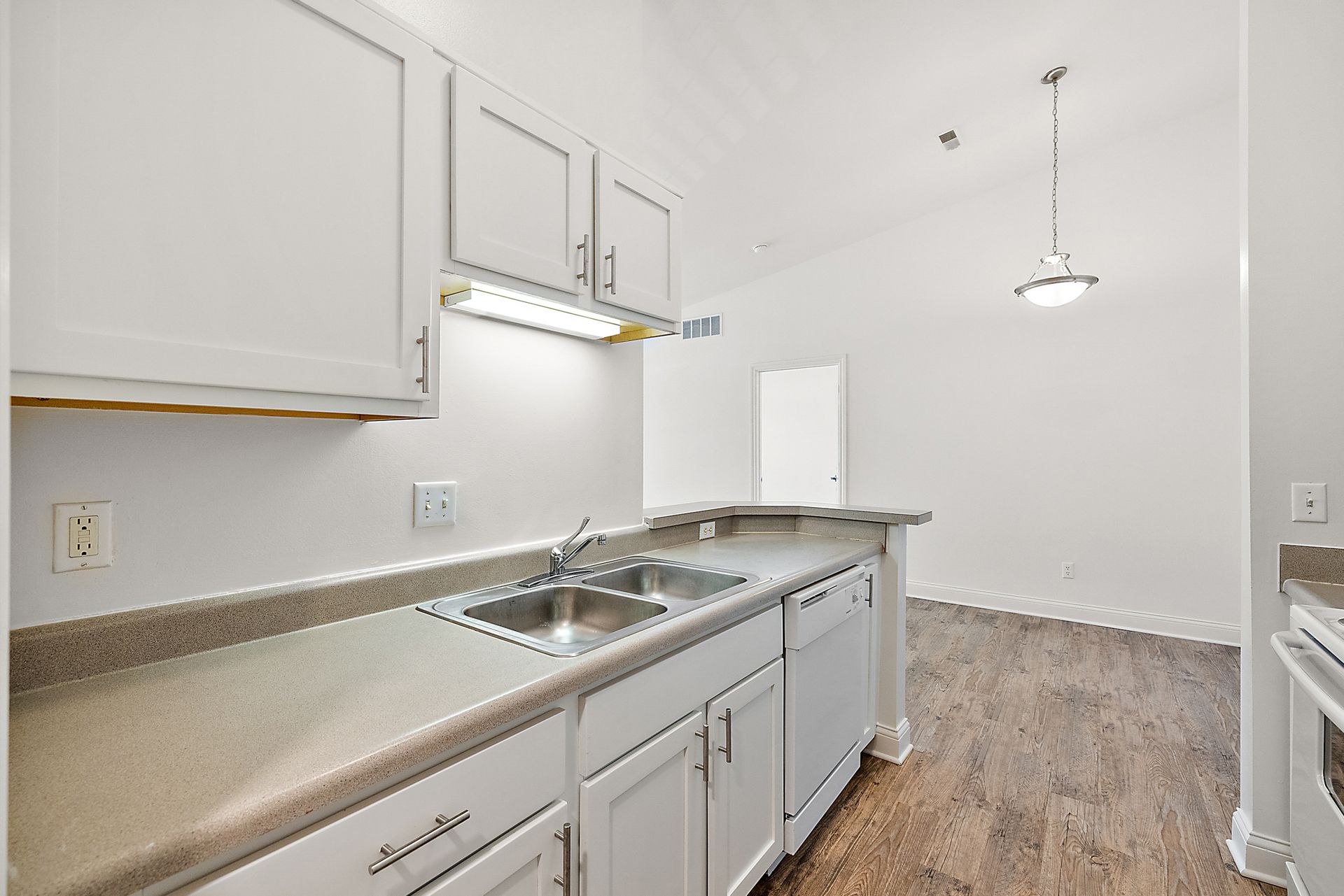 A kitchen with white cabinets , a sink , and a stove.