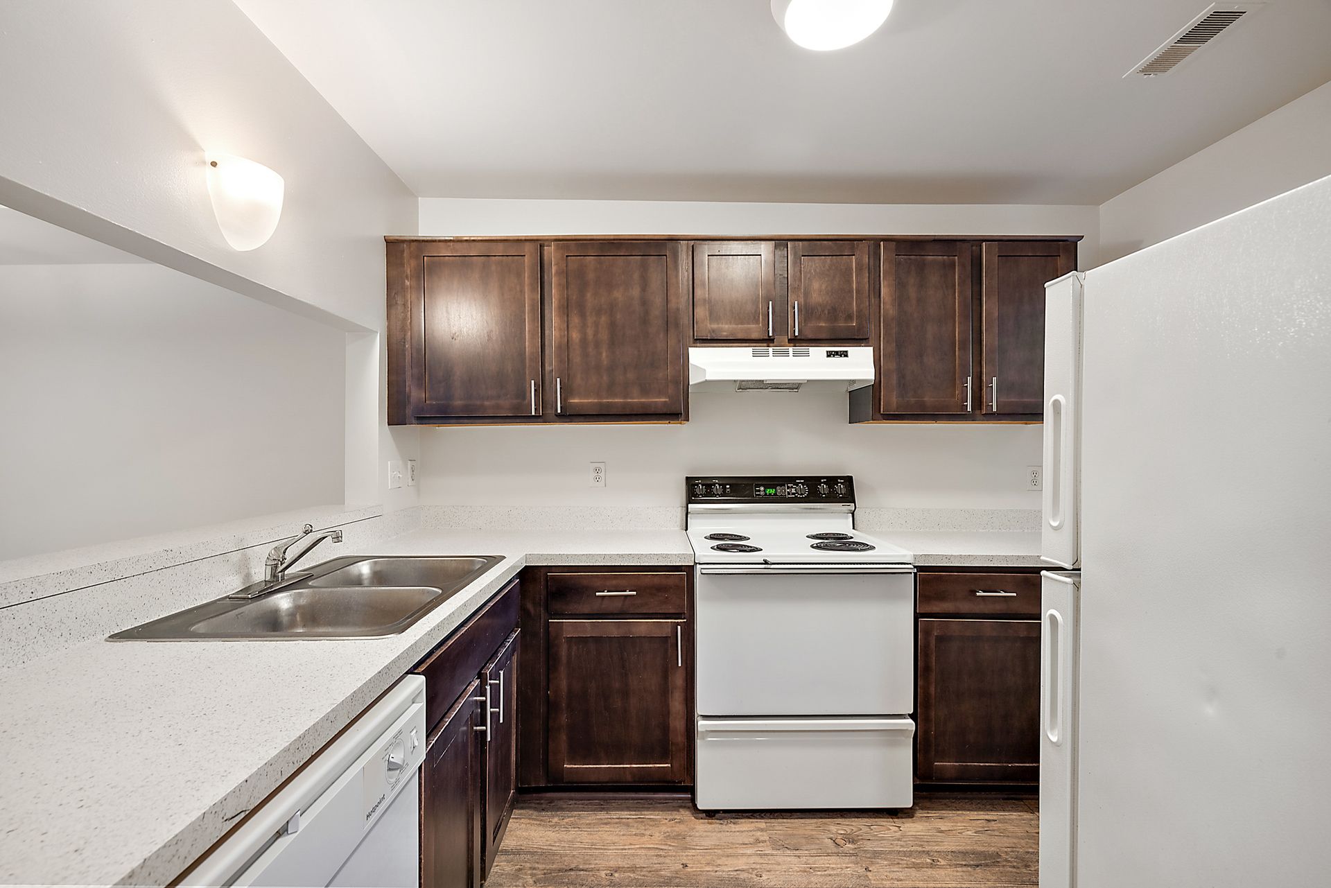 A kitchen with white appliances and brown cabinets