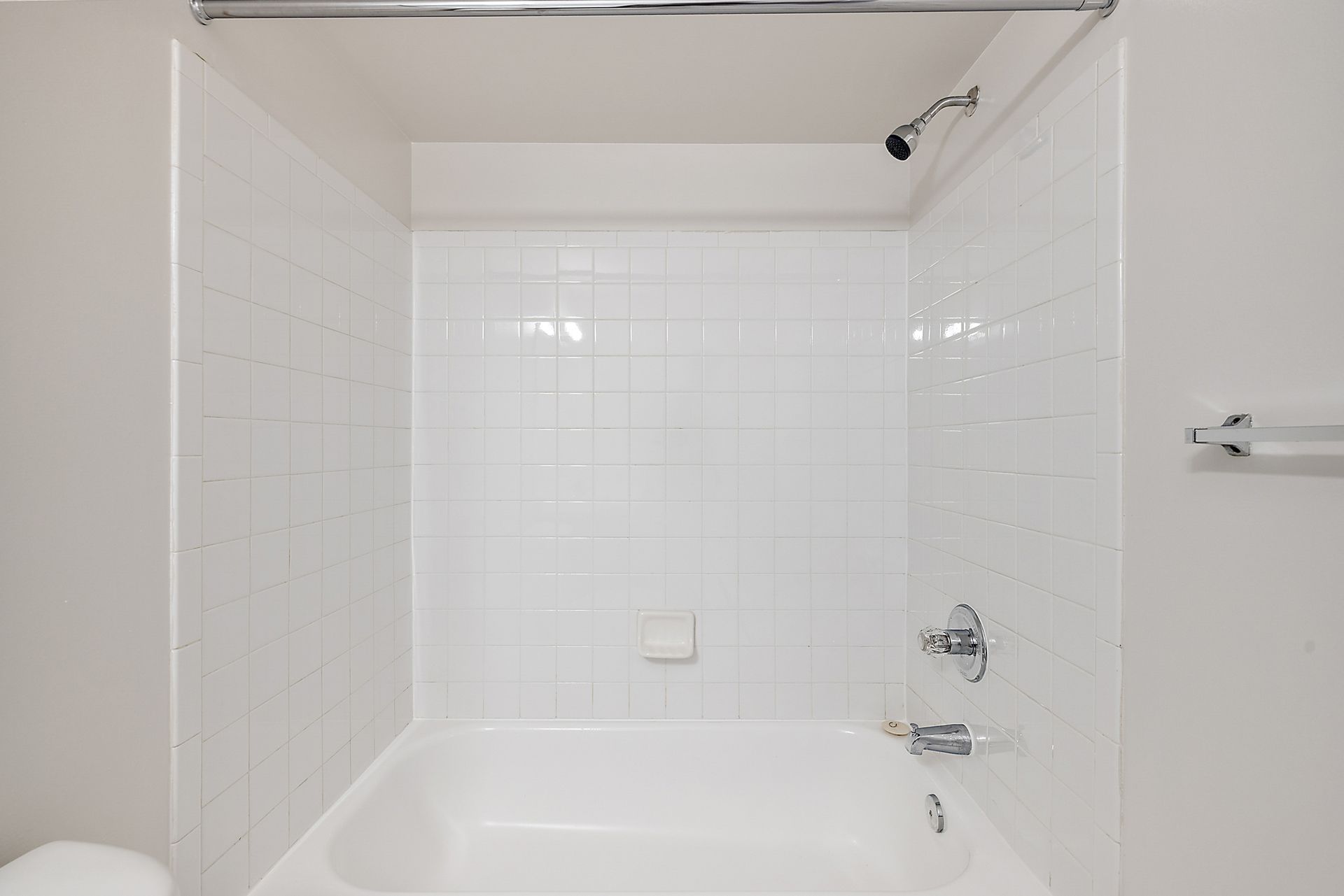 A bathroom with a bathtub , toilet and shower.
