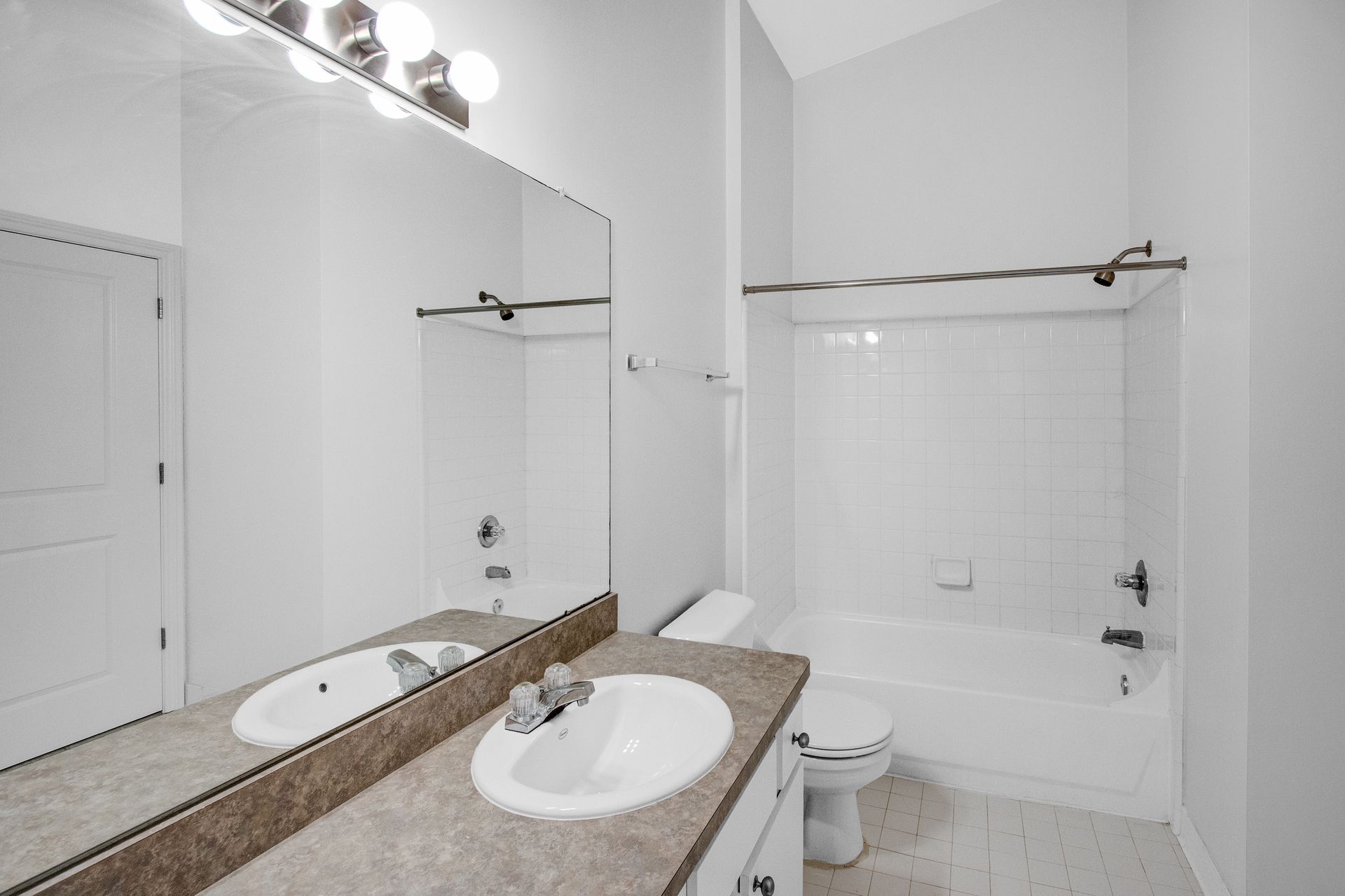 A bathroom with two sinks , a toilet , and a bathtub.