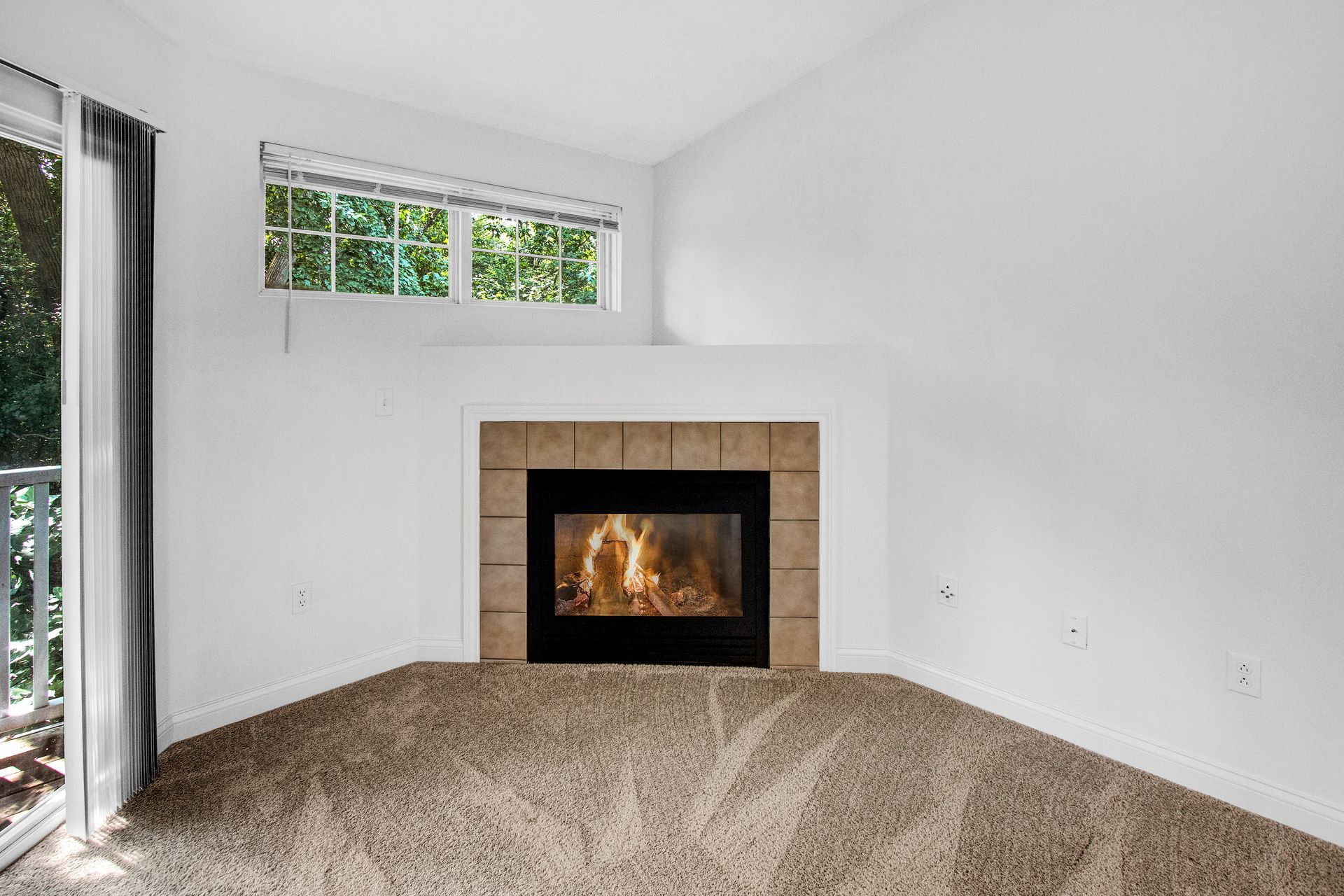 A living room with a fireplace and a sliding glass door.