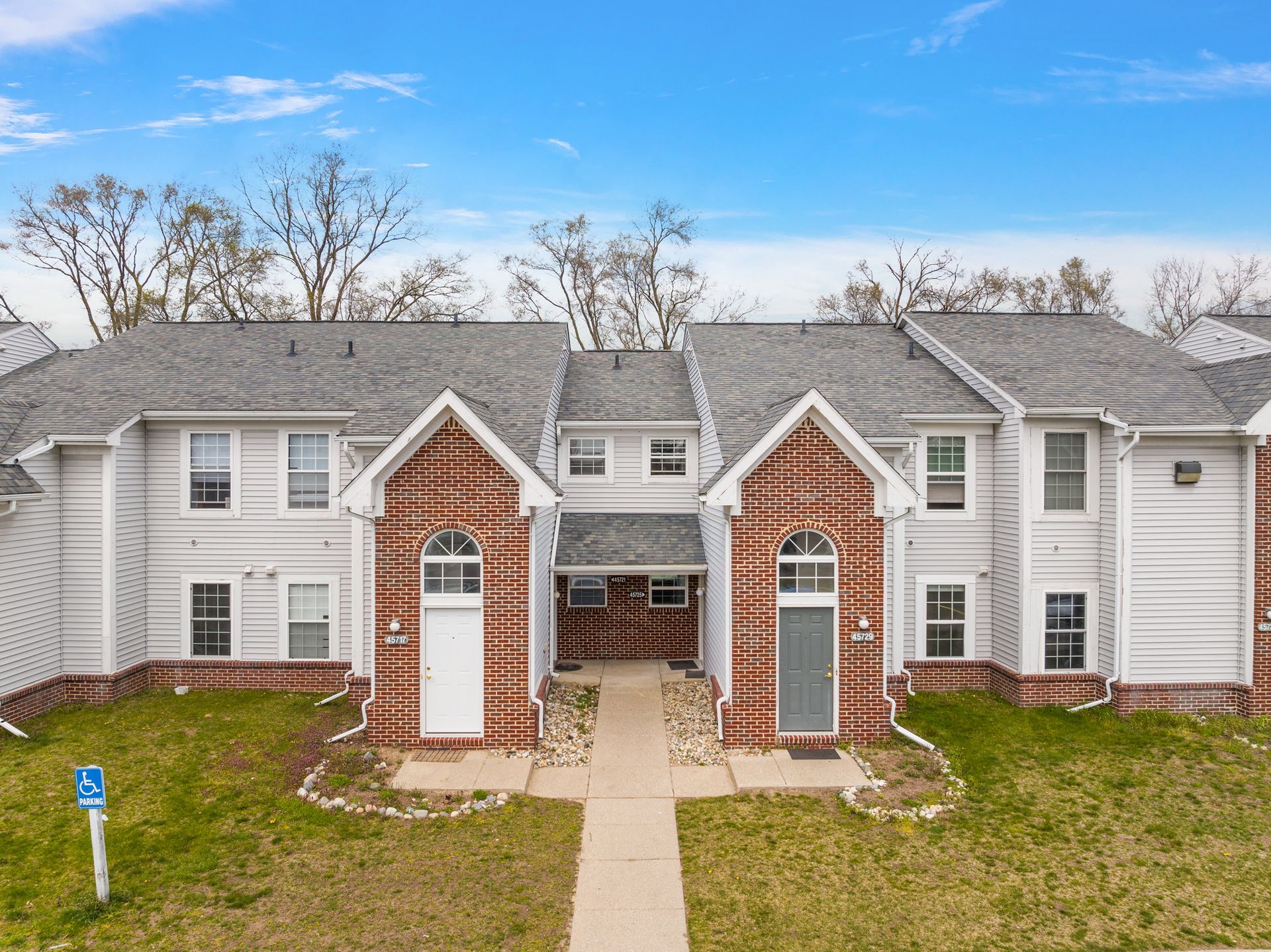 An aerial view of a row of apartment buildings with a handicapped sign in front of them.