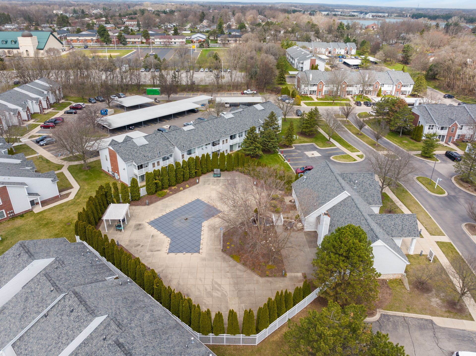An aerial view of a residential area with a pool in the middle of it.
