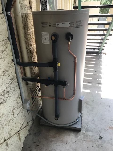 Water Heater Against Wall With Copper And Black Insulated Pipes — David Talbot Plumbing in Cranbrook, QLD