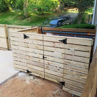 A wooden fence with a car parked behind it.