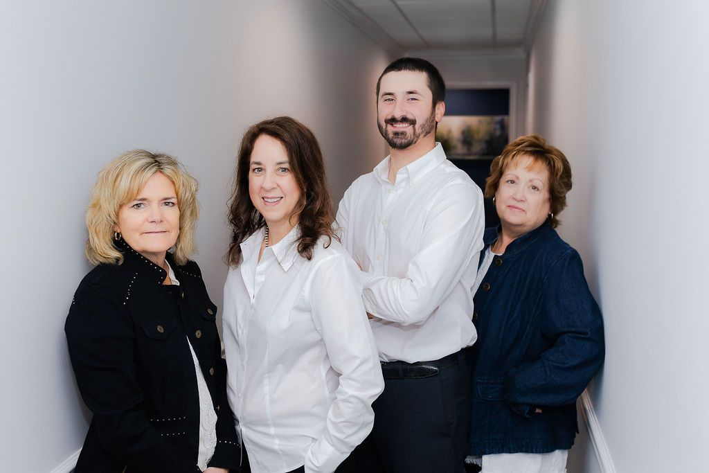 The Horne Insurance Agency team members are posing for a picture in a hallway.