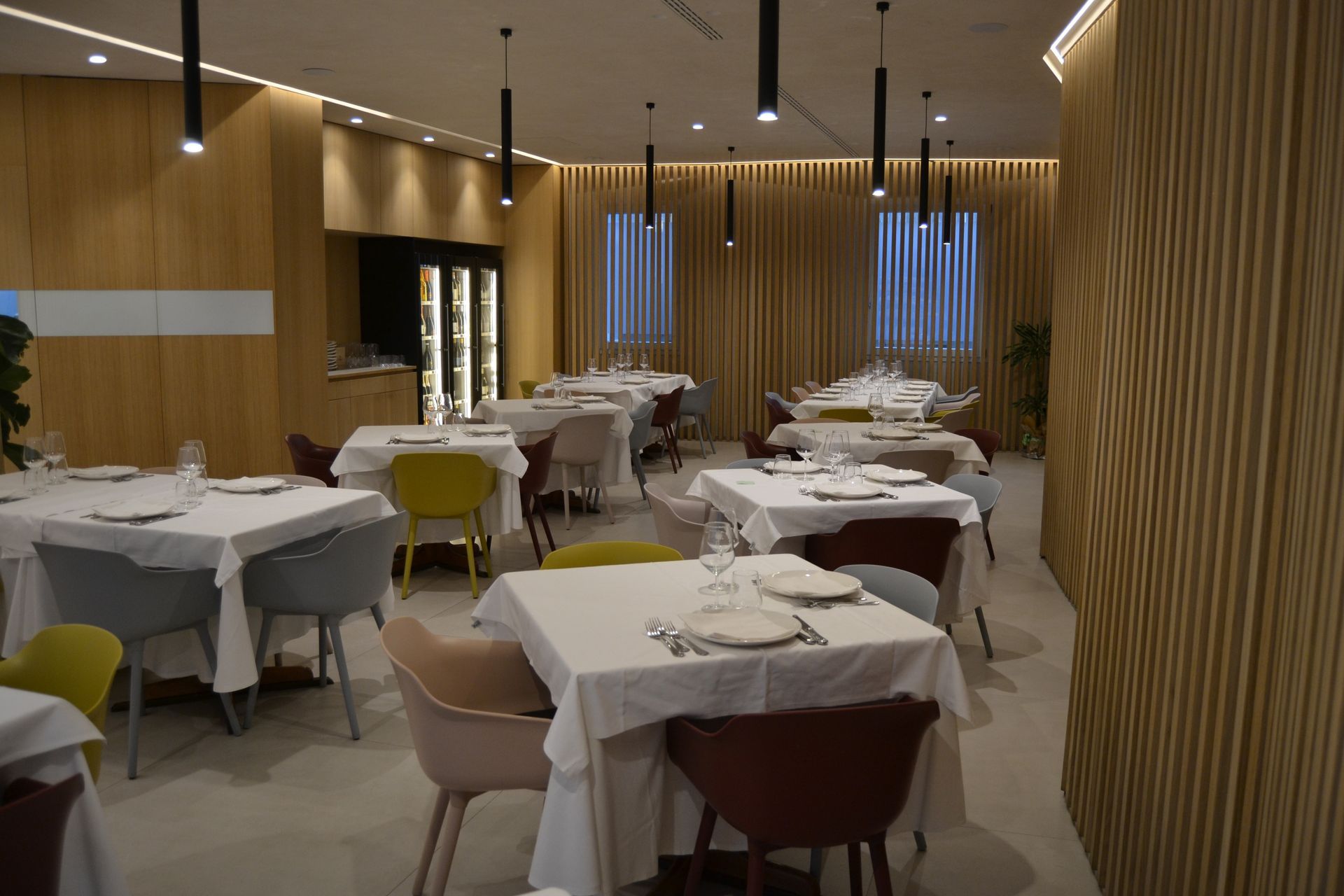 Una sala da pranzo con tavoli e sedie apparecchiati per il pasto.