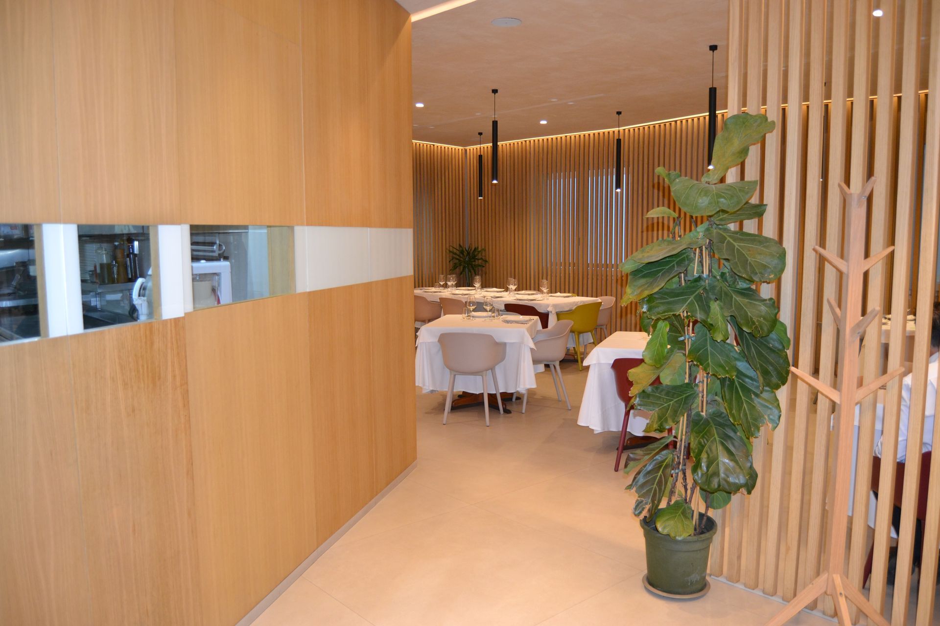 Un lungo tavolo con piatti, bicchieri e sedie in un ristorante.