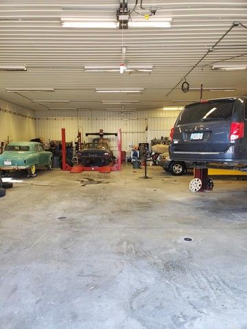 A car is sitting on a lift in a garage.