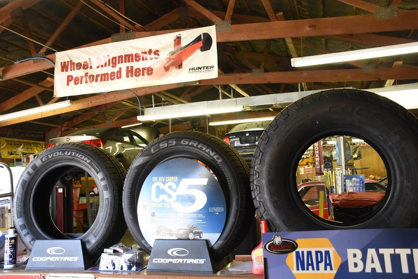 Three tires are on display under a sign that says napa battery