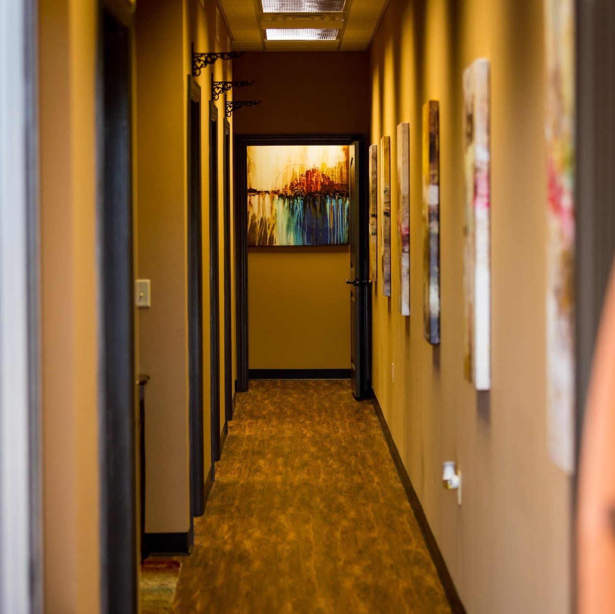 A long hallway with a painting on the wall