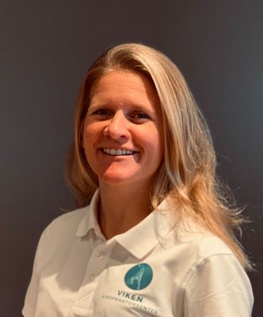 Fysioterapeut Tonje Møyner. Kvinne med blondt hår iført en hvit poloskjorte med logo, smilende.