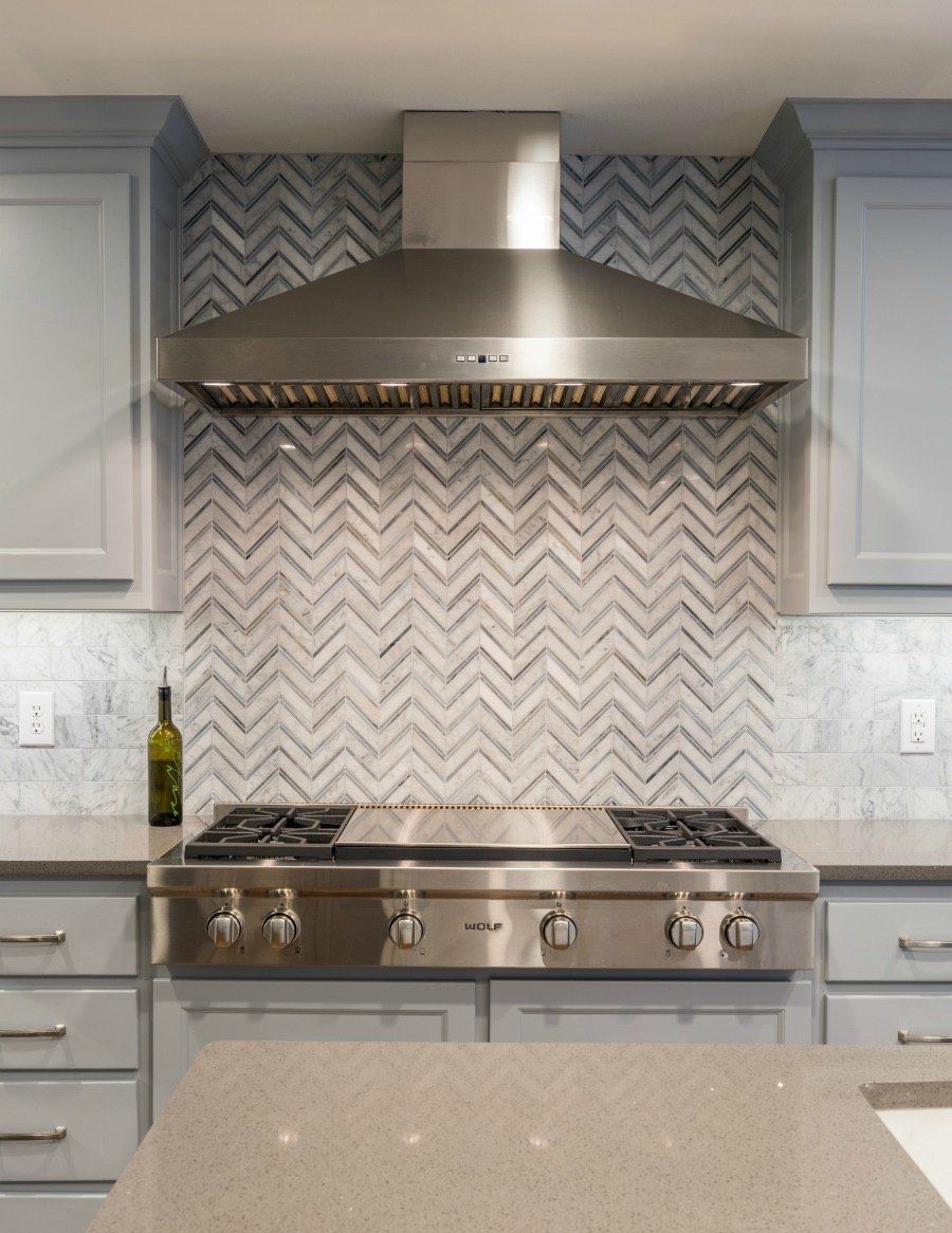 a kitchen with a stove and a bottle of wine on the counter