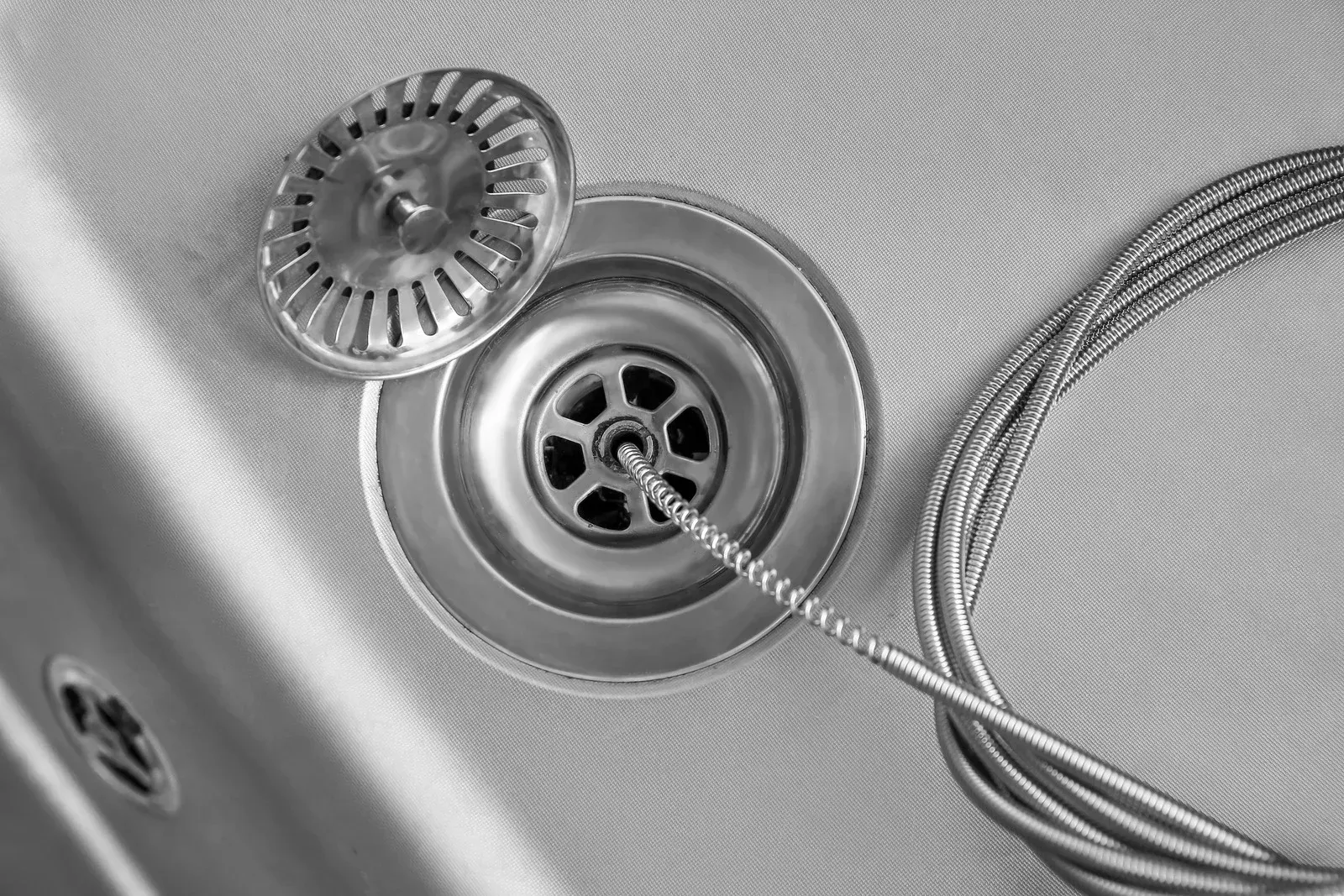 Sink drain with a hair strainer, and a plumbing snake.