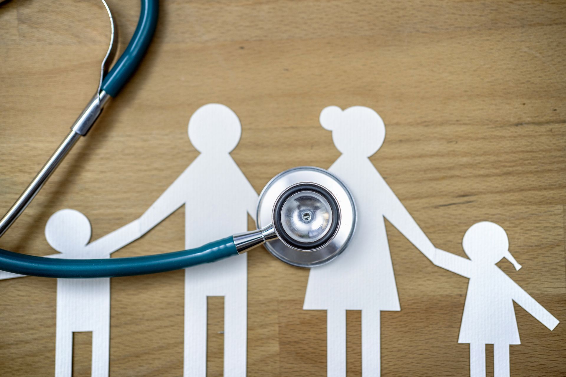 Family cutouts with stethoscope, concept of family health.