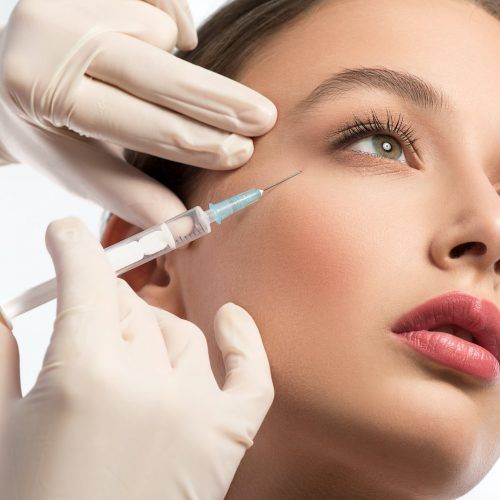 A woman is getting an injection in her face.