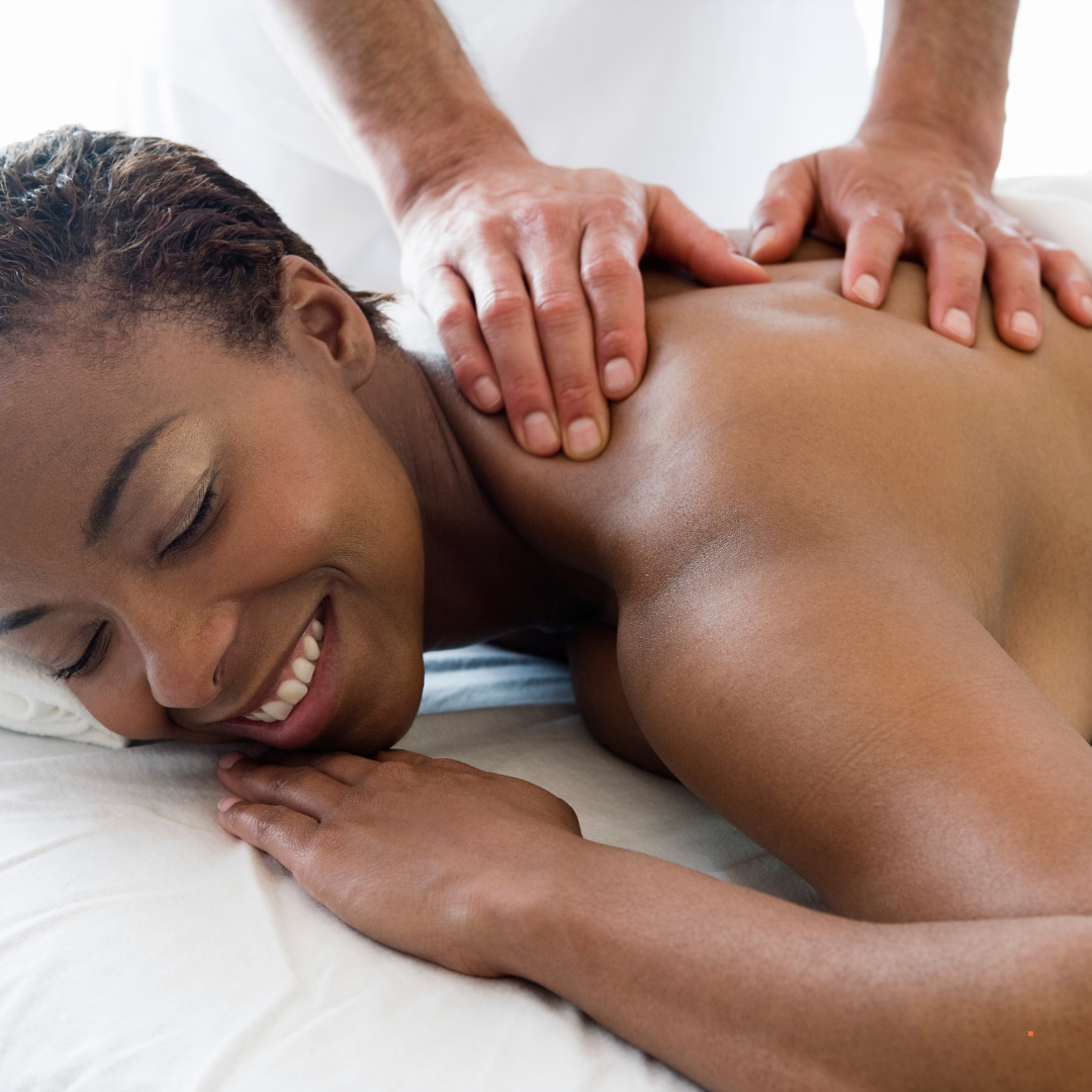 A woman is smiling while getting a massage on her back