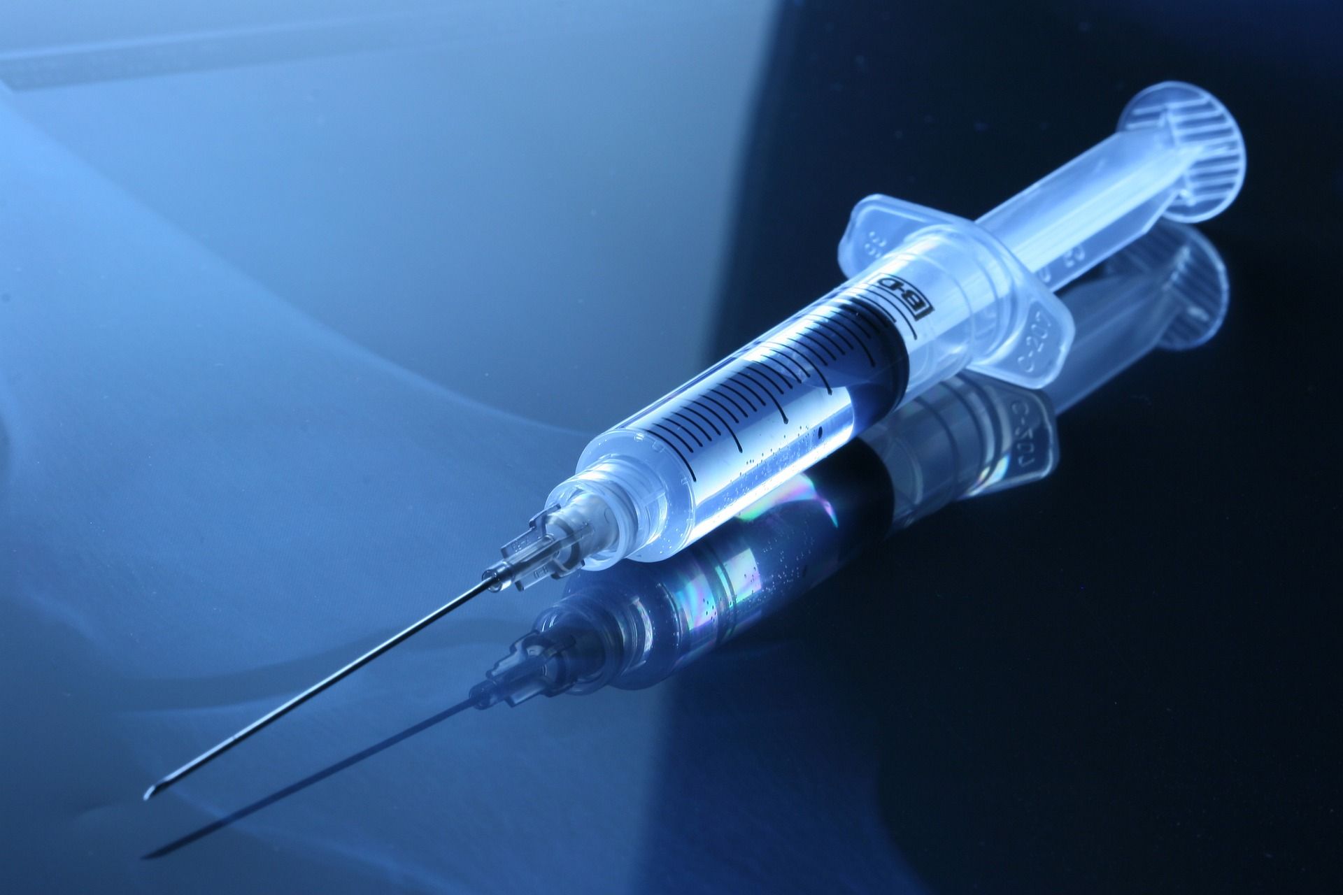 A syringe with a needle is sitting on a table.