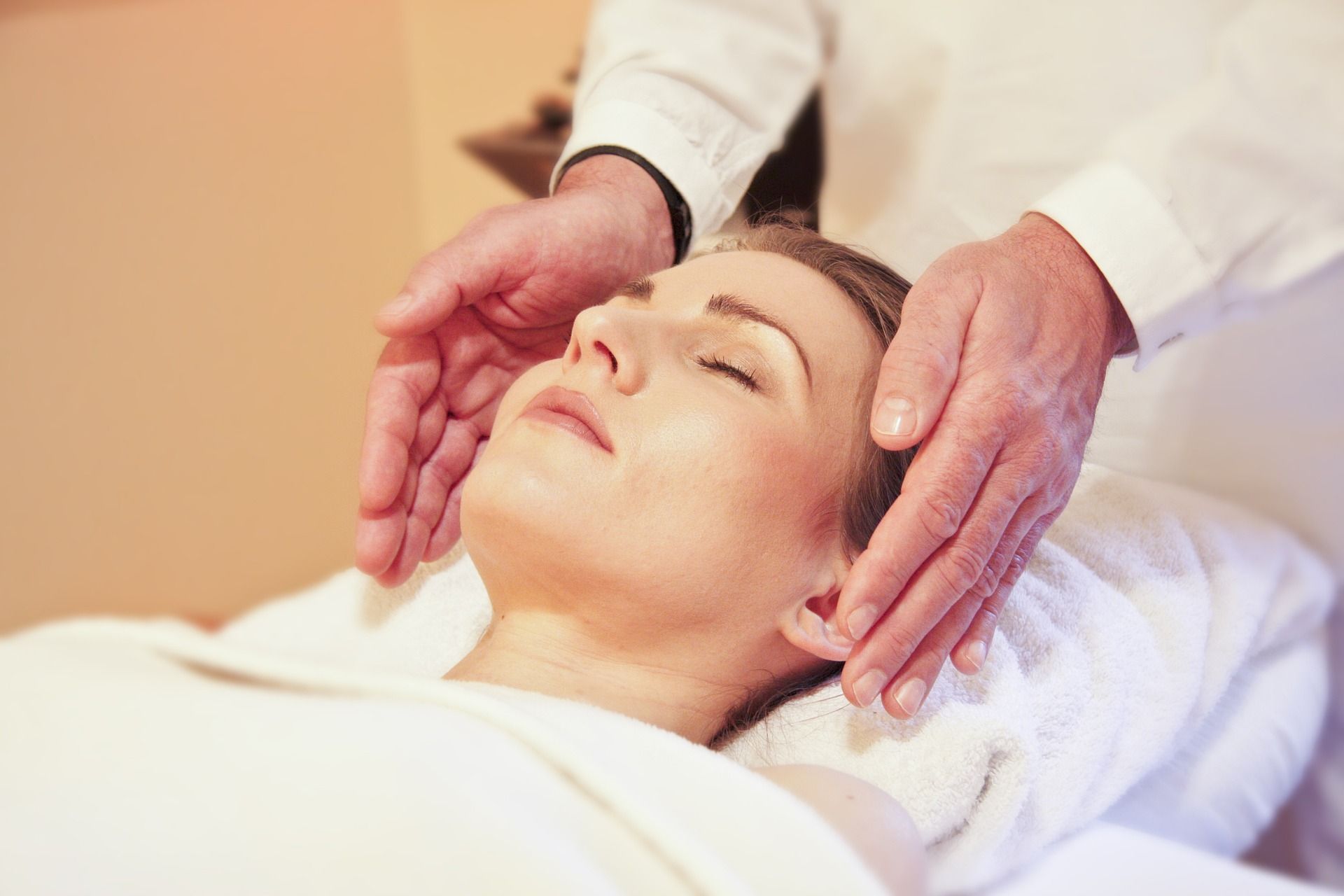 A woman is laying on a bed getting a massage from a man.