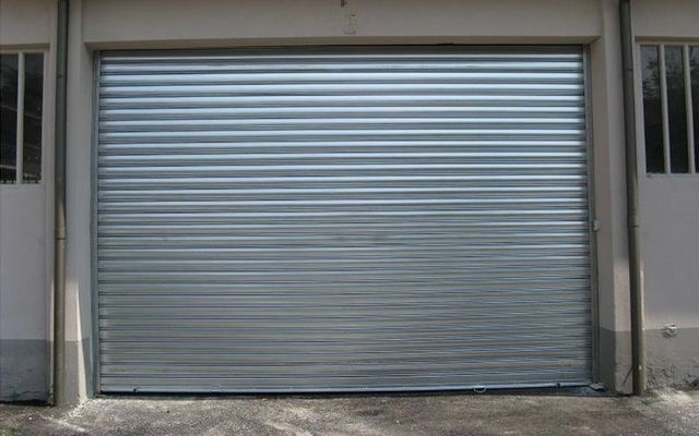 Una porta di garage con una serranda metallica è aperta.