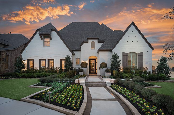 A large house is being built in the middle of a dirt field.