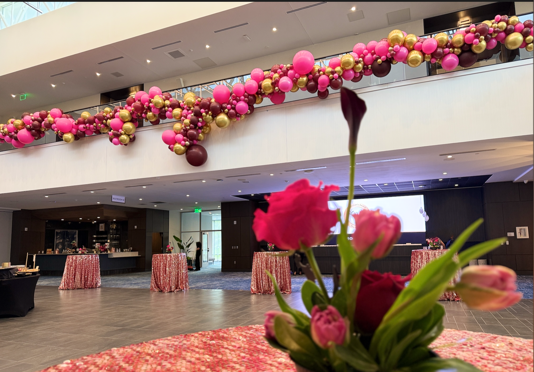 Corporate Balloon Garland Large Organic Balloon Garland Installation for The Hartford in colors of gold, cranberry, and hot pink.