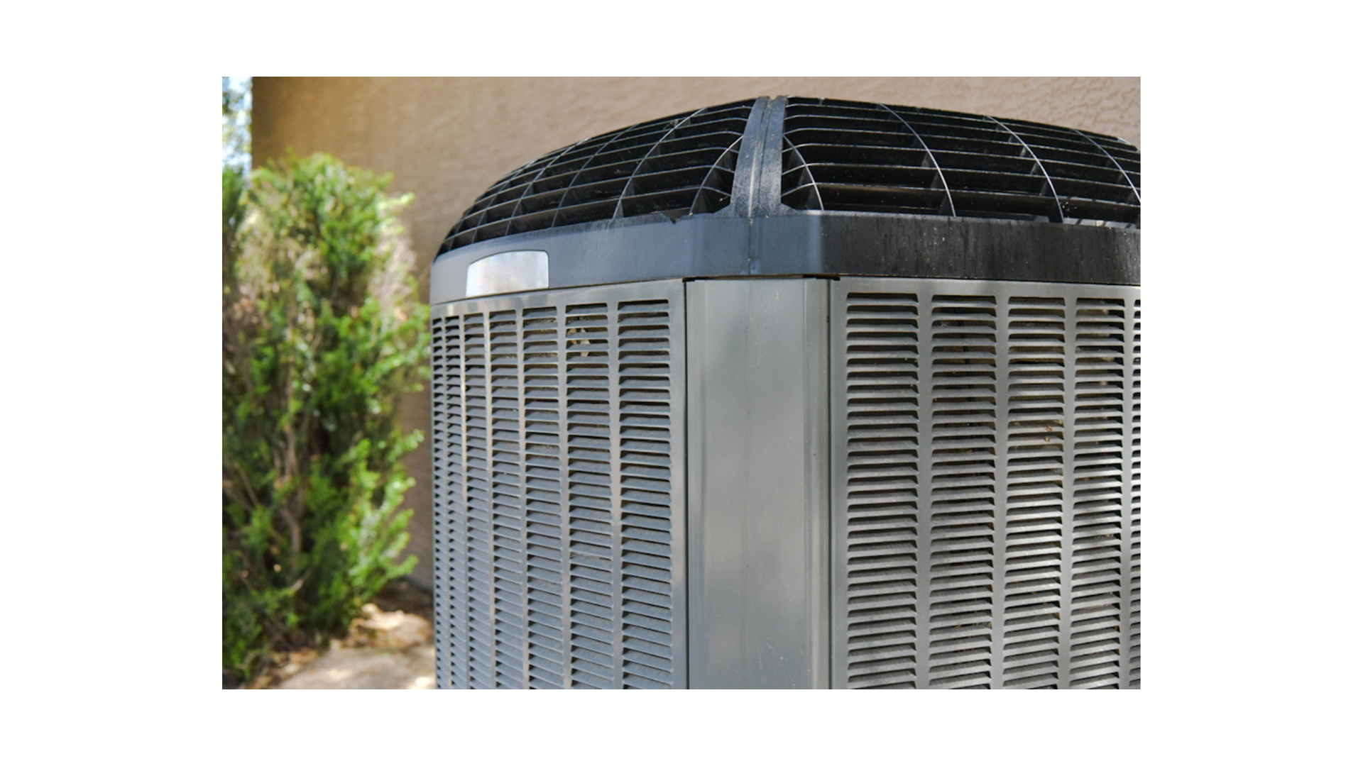 A large air conditioner is sitting outside of a building.