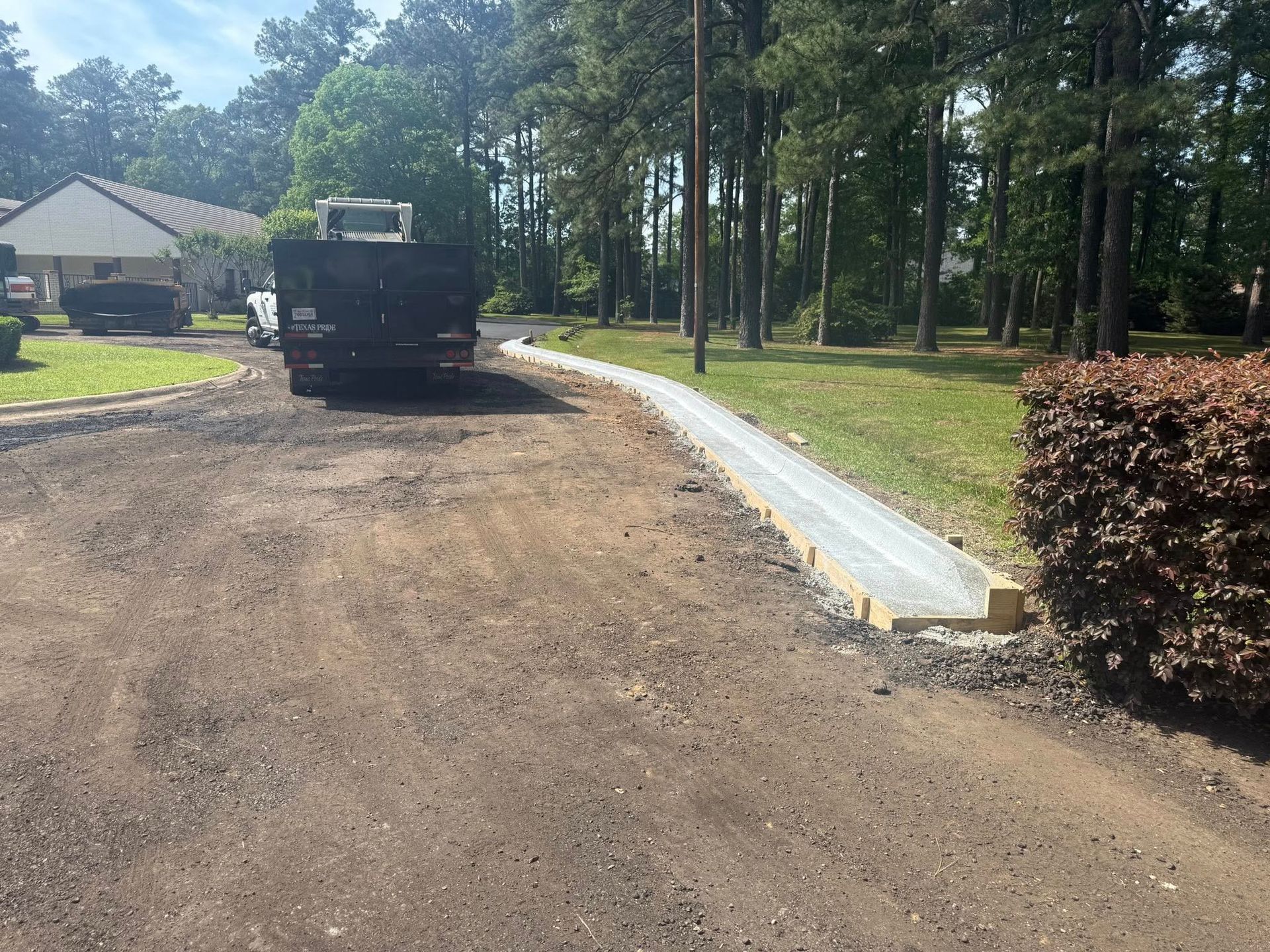 A truck is parked on the side of a dirt road.