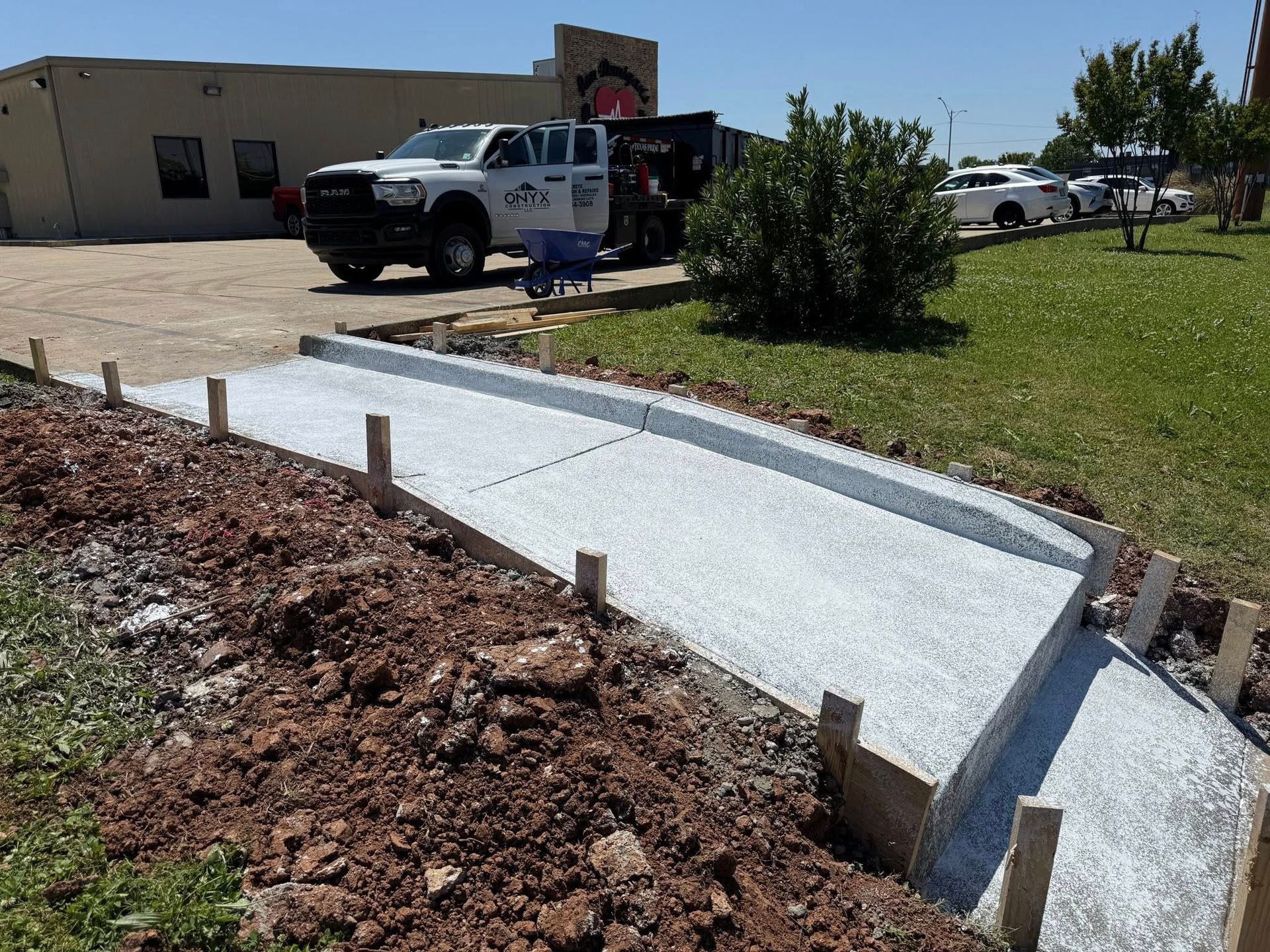 A concrete walkway is being built in front of a building.