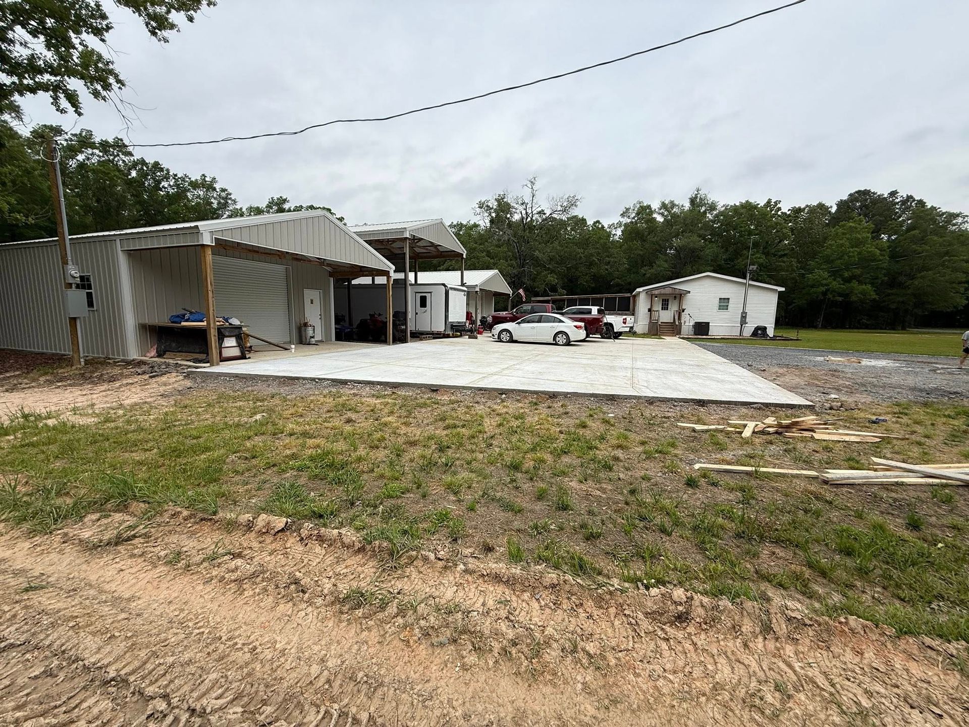 A lot of cars are parked in front of a building in a field.